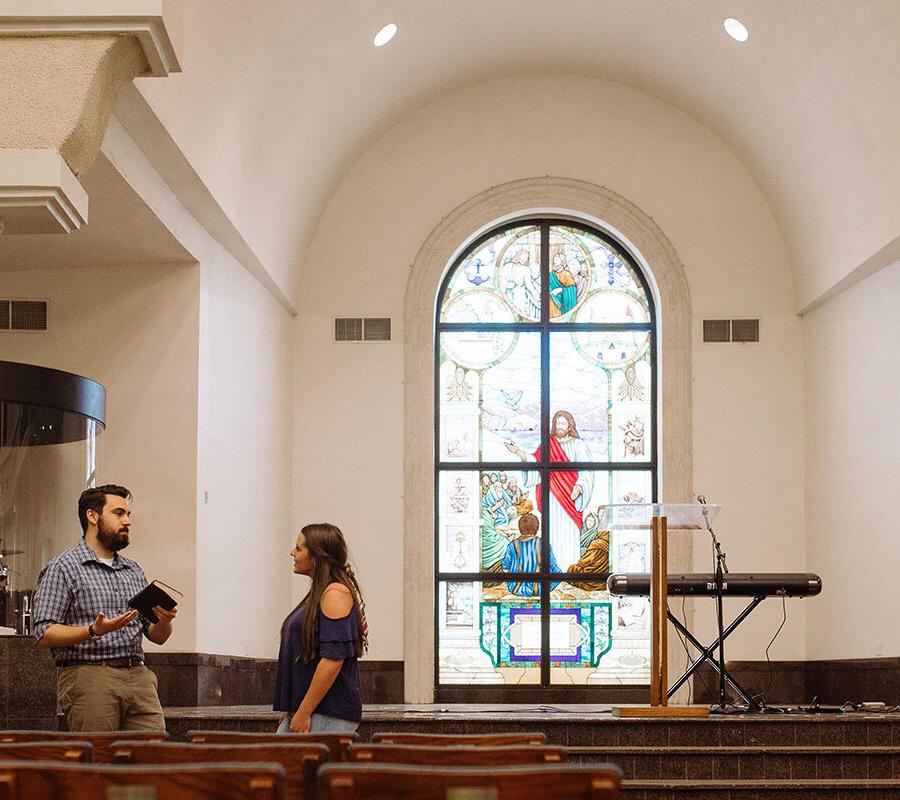ministry student in the chapel providing counsel to another student